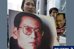 China retiene a la esposa del ganador del Nobel de la Paz Unos manifetantes sotienen pancartas a favor del premio Nobel durante una manifestación en Hong Kong, el 10 de octubre de 2010.