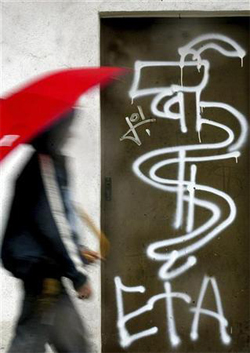Un joven pasa junto a un logo de ETA en una fotografía de archivo de 2004 tomada en las calles de Guernica.