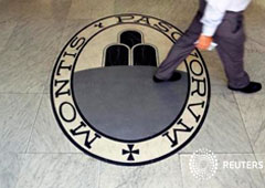 Un hombre camina sobre un logo del banco Monte Dei Paschi Di Siena en Roma, Italia, el 24 de septiembre de 2013