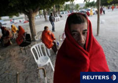 Varias personas esperan tras pasar la noche al raso en Lorca el 12 de mayo de 2011.