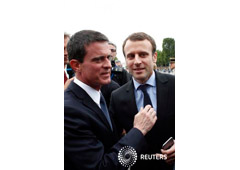 Valls (I) saluda a Macron en un acto en París el 14 de julio de 2016