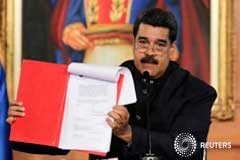 Maduro convoca la Asamblea Constituyente y la oposición llama a rebelarse Maduro muestra un documento durante una ceremonia en el palacio de Miraflores, Caracas, el 1 de mayo de 2017
