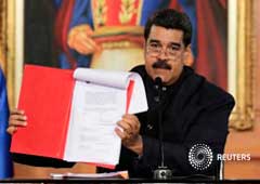 Maduro muestra un documento durante una ceremonia en el palacio de Miraflores, Caracas, el 1 de mayo de 2017