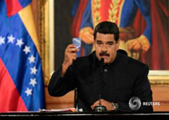 El presidente venezolano Nicolas Maduro muestra una copia de la constitución venezolana en Caracas, el 1 de mayo de 2017