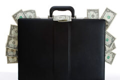 Cesión de la cartera de clientes, ¿cómo tributa? Un maletín en el cual asoman billetes de dólar