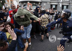 Un policía golpea con una porra a un manifestante después de los antidisturbios cargasen contra quienes se manifestaban a las puertas del Congreso de los Diputados en Madrid Un policía golpea con una porra a un manifestante después de los antidisturbios cargasen contra quienes se manifestaban a las puertas del Congreso de los Diputados en Madrid