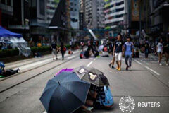 Ni la lluvia ni los truenos detienen a los manifestantes en Hong Kong Manifestantes se cobijan bajo paragüas mientras bloquean una zona próxima a la sede del gobierno en en Hong Kong el 1 de octubre de 2014