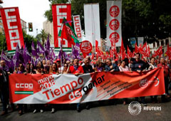 Trabajadores y sindicalistas con banderas de las organizaciones UGT y Comisiones Obreras en la concentración del primero de mayo celebrada en Madrid