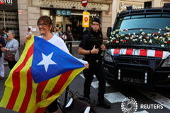 El independentismo toma la calle en Cataluña a siete días del referéndum Una mujer con una Estelada (bandera catalana separatista) junto a un coche de los Mossos d'Esquadra lleno de flores tras una manifestación a favor del referéndum del 1 de octubre, en Barcelona, 24 de septiembre de 2017