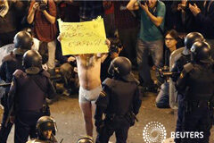 Miles de personas protestan ante un Congreso blindado Un manifestante en ropa interior sostiene una pancarta en la que puede leerse "Esto es un Madrid sin Esperanza" ante los policías antidisturbios en las afueras del Congreso en Madrid, el 25 de septiembre de 2012