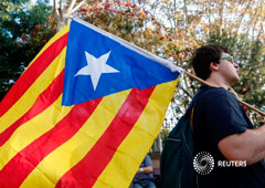 Un manifestante lleva una bandera independentista catalana frente al Parlamento catalán, en Barcelona, el 27 de octubre de 2017