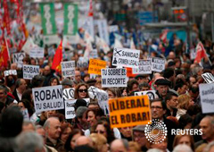 Trabajadores de salud y simpatizantes sostienen pancartas en una protesta contra recortes de sanidad en Madrid, el 17 de febrero de 2013