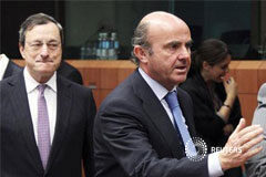 España pide al BCE que actúe para rebajar la presión El presidente del Banco Central Europeo, Mario Draghi (centro), mirando al ministro español de Economía y Competitividad, Luisde Guindos