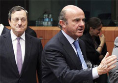 El presidente del Banco Central Europeo, Mario Draghi (centro), mirando al ministro español de Economía y Competitividad, Luisde Guindos