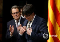 Carles Puigdemont mira una medalla recibida del anterior presidente catalán, Artur Mas (izquierda), durante la toma de posesión de Puigdemont como presidente de la Generalitat de Catalunya en el Palau de la Generalitat en Barcelona, 12 de enero de 2016