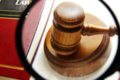 Informes periciales contradictorios: ¿sobreseimiento o enjuiciamiento? Una lupa aumentando un mazo