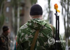 Miliciano prorruso con una flor en el fusil en las celebraciones por el día de la Victoria en Slaviansk, en el este de Ucrania, el 9 de mayo