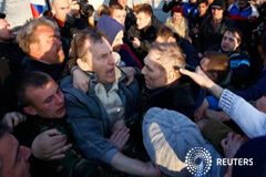 Tropas ucranianas aterrizan en ciudad del Este, luego se retiran a la base Militantes pro rusos rodean a un general ucraniano, Genady Krutov (en el centro derecha), en frente de una base aérea ucraniana en Kramatorsk, al este de Ucrania, el 15 de abril de 2014