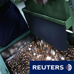 un trabajador recoge monedas de 5 céntimos de euro en la Casa de la Moneda en Madrid, el 6 de noviembre de 2008.