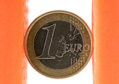 Una moneda de euro sostenida entre dos columnas naranjas