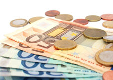 ¿Cómo reducir el salario sin contar con el acuerdo con los trabajadores? Monedas sobre billetes de 50 euros