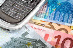 Se está creando un nuevo mercado: el de pago por teléfono móvil Un movil encima de billetes de euro.