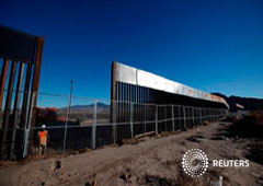 Un empleado junto a una sección de la valla fronteriza entre Estados Unidos y México en Sunland Park, frente a lCiudad Juárez, Mexico, el 25 de enero de 2017
