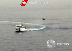 Nave de la guardia costera italiana y helicóptero durante las operaciones de búsqueda y rescate de barco que naufragó frente a la costa libia, 19 abr, 2015