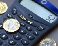 La fijación del precio en los servicios legales Calculadora junto a monedas