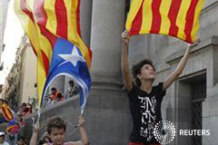 Fitch amenaza con rebajar el rating a Cataluña Varios niños juegan con banderas catalanas en Barcelona
