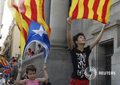 Varios niños juegan con banderas catalanas en Barcelona