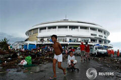 El presidente filipino baja la cifra de muertos por el tifón a 2.000 ó 2.500 Unos niños juegan a las afueras de un centro de convenciones en Tacloban, convertida en un albergue para refugiados del tifón Haiyan, el 12 de noviembre de 2013