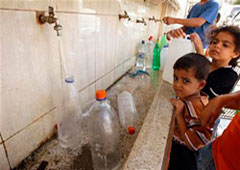 niños palestinos llenan botellas de agua en un grifo público en Khan Younis, en el sur de la Franja de Gaza, el 26 de octubre de 2009.