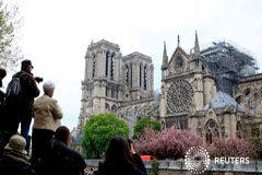 Francia lamenta daños a Notre Dame, no encuentra señales de que incendio haya sido provocado Transeúntes toman fotografías de la catedral de Notre-Dame en París después del incendio que destruyó partes de la estructura gótica. April 16, 2019
