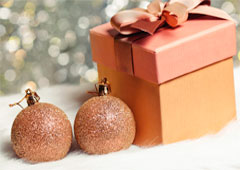 Dos bolas de navidad junto a una caja de regalo