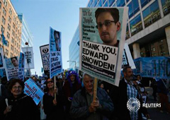 Unos manifestantes apoyan al excontratista de la NSA Edward Snowden, que reveló el vasto programa de espionaje de EEUU que afecta a España, en una marcha con el lema 