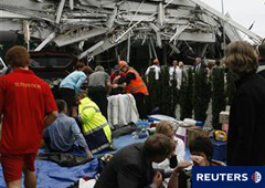 Unas personas son atendidas mientras los servicios de rescate buscan a los atrapados en el derrumbado edificio de la Pyne Gould Corporation en Christchurch.
