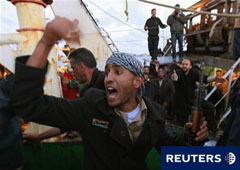 Un rebelde pide a unos curiosos que se aparten para permitir que los civiles libios sean evacuados en Bengasi, el 18 de abril de 2011.