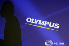 Detenido el ex presidente de Olympus por un escándalo contable Imagen de un empleado de la empresa cuya silueta aparece reflejada en una pantalla con el logo de Olympus anes de una rueda de prensa en Tokio el 13 de febrero.