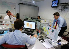 Operadores miran los ordenadores durante una subasta de bonos en Madrid, en una foto de archivo del 5 de diciembre de 2012