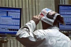 El Ibex-35 recorta pérdidas y los bancos repuntan pese a Moody’s un operador se cubre la cabeza con un diario mientras observa la cotización de la Bolsa de Madrid