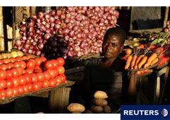 Una joven posa junto a un puesto de vegetales en Tsangano, en el centro de Malaui, el 19 de abril de 2008.