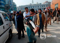 Un hombre lleva en brazos a un estudiante herido durante el ataque, tras recibir asistencia en un hospital en Peshawar, el 16 de diciembre de 2014
