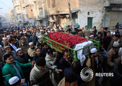 Un grupo de personas transporta un ataúd de un estudiante asesinado en el ataque del martes en la escuela de hijos de militares, durante su funeral en Peshawar, el 17 de diciembre de 2014