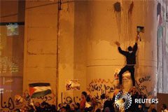 La ONU da su reconocimiento implícito a un Estado palestino Palestinos toman parte en una manifestación mientras otro escala por el muro israelí de la controversía en la ciudad cisjordana de Belén, el 29 de noviembre de 2012