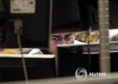 Un operador observa varias pantallas de ordendor durante una subata de bonos en Madrid