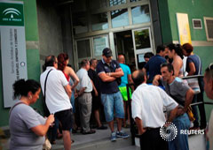 Varias personas esperan para entrar en una oficina de empleo en Málaga, el 4 de julio de 2016