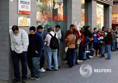 Gente espera en una cola para entrar en una oficina de empleo en Madrid, el 25 de abril de 2013