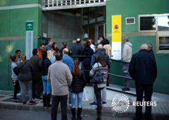 Un grupo de personas espera para entrar en una oficina de empleo en Málaga