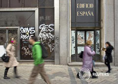unos peatones psasan junto a un edificio vacío en el centro de Madrid, el 19 de abril de 2012